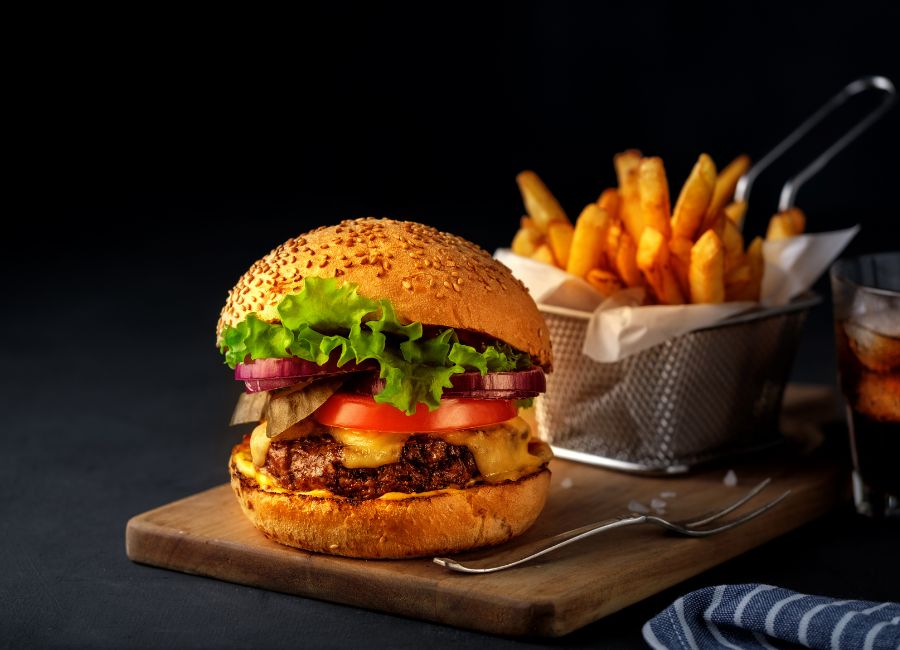 A Beef Gourmet Burger with lettuce, onions, tomato and cheese with Crispy Chips on the side